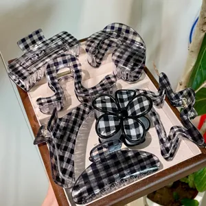 Vista dettagliata di vari accessori per capelli con motivo a quadri bianchi e neri.