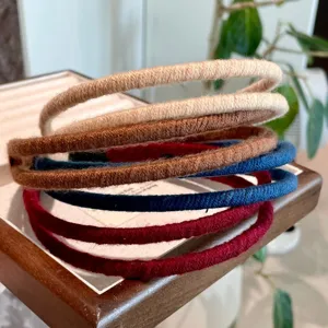 Detailed shot of multi-color yarn-wrapped thin headbands, showcasing stacked textures.
