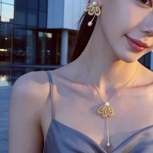 Ensemble de boucles d'oreilles et collier perles fleur de dentelle or elegant.