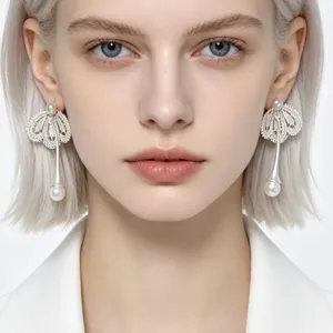 Élégantes boucles d'oreilles pendantes en perles et dentelle argentée, chic et luxueuses.