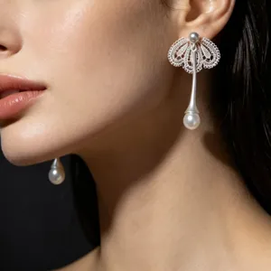 Vue rapprochée détaillée de boucles d'oreilles pendantes en dentelle argentée.