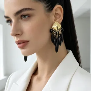 Gros plan détaillé de boucles d'oreilles pendantes géométriques dorées et perles noires sur modèle.