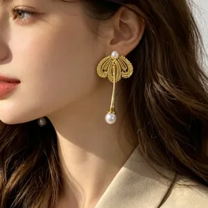 Détail en gros plan des boucles d'oreilles perles et pétales de dentelle élégants et fins.