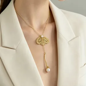Gros plan détaillé d'un collier délicat en dentelle dorée perle avec pendentif.
