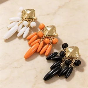 Gros plan détaillé de boucles d'oreilles carrées vintage avec pampilles de gouttes d'eau.