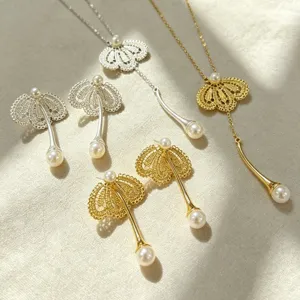 Vue détaillée de l'ensemble de boucles d'oreilles et collier perles en dentelle dorée et argentée.