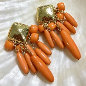 Boucles d'oreilles pendantes vintage carrées avec des perles orange vif et des chaînes dorées.