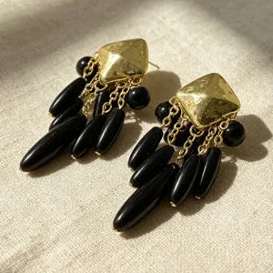 Boucles d'oreilles pendantes gouttes noires vintage, clous carrés dorés, détail bijoux rétro.