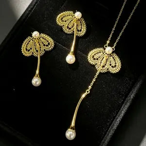 Ensemble de bijoux en perles et dentelle dorée comprenant boucles et collier délicat.