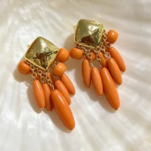 Gros plan détaillé de boucles d'oreilles carrées rétro avec pampilles de perles en forme de goutte.