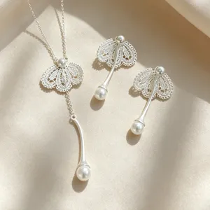 Élégant détail de collier et boucles d'oreilles perles dentelle, ensemble de bijoux en métal brillant.