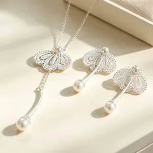 Ensemble élégant de collier et boucles d'oreilles perles et dentelle argentée, bijou luxueux.