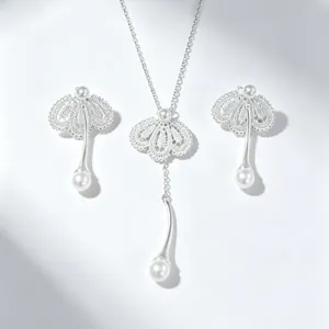 Gros plan détaillé du collier pendentif perle dentelle argentée et boucles d'oreilles.