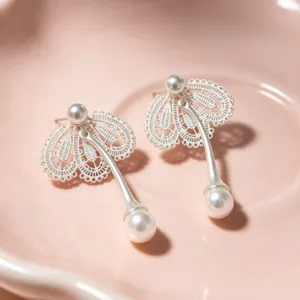 Vue détaillée de superbes boucles d'oreilles pendantes perles dentelle argentées.