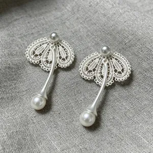 Élégantes boucles d'oreilles perles en dentelle, design argenté exquis, détail bijou mode.