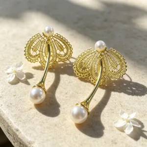 Gros plan détaillé des boucles d'oreilles perles en dentelle élégantes avec finition dorée.