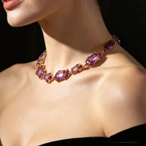 Detailed close-up of a vintage court-style purple gemstone necklace with intricate gold setting.