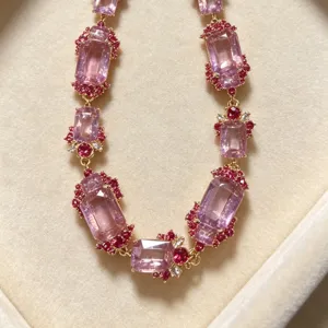 Detailed view of vintage baroque pink crystal necklace, ornate gold-toned statement jewelry piece.