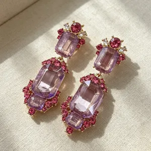 Close-up detail of vintage palace style crystal earrings with purple and pink rhinestones.