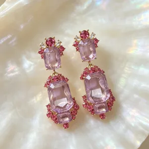 Detailed shot of vintage palace-style purple crystal drop earrings with intricate pink rhinestones.