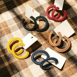 Gedetailleerd overzicht van gevlochten lederen C-creolen, trendy oorbellen voor vrouwen.