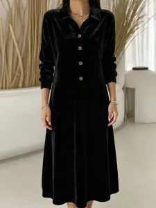 Close-up detail view of black velvet long sleeve midi dress with lapel collar and buttons.