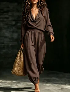 Detail shot of the brown cowl neck long sleeve top and jogger pants set with straw bag.