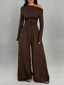 Detailed view of the stylish brown asymmetric off-shoulder top and wide-leg trousers set.
