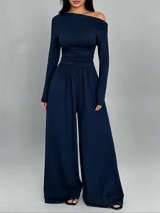 Detail view of the navy blue off-shoulder long sleeve wide leg jumpsuit fabric texture.