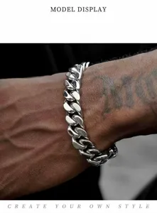 Primo piano dettagliato di un bracciale a catena cubana in acciaio per uomo al polso.