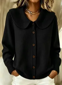 Black knit cardigan detail featuring oversized doll collar and brown button closure.