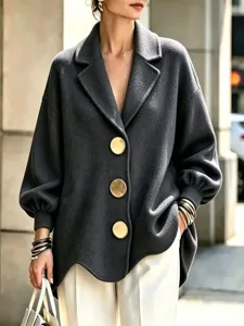 Close-up detail of the women's grey oversized wool coat featuring large gold metal buttons.