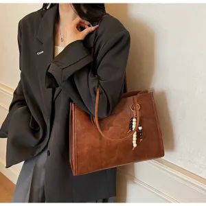 Detailed view of the vintage brown suede large capacity tote bag with bead charm strap.