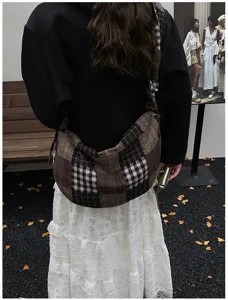 Detailed shot of retro plaid shoulder bag, casual slouchy messenger bag for autumn and winter.