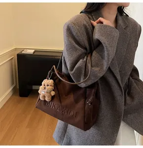 Vintage brown suede tote bag for women, large capacity casual shoulder handbag with charm.