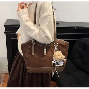 Gros-plan sur le sac cabas marron en daim avec pendentif ours en peluche, style automne élégant.