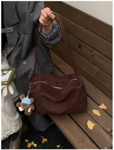 Brown suede shoulder bag with zip closure and cute bear pendant, stylish commuter tote.