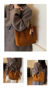 Brown suede tote bag detail view showing soft texture, leather shoulder strap, and wood bead charm.