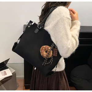Detail view of black retro tote bag, large capacity commuting shoulder bag for women.