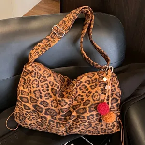 Retro leopard print crossbody tote bag with adjustable strap and cute pom-pom charms.