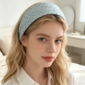 Gros plan detail d'un serre-tête large en tissu bleu clair a pois porte en interieur.