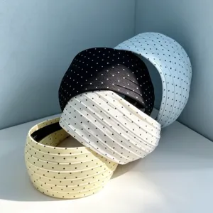 Vue rapprochée détaillée de serres-tête larges à pois élégants dans des couleurs variées.