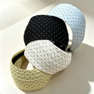 Gros plan de bandes de cheveux larges à pois empilées dans diverses couleurs et textures.