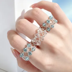 Detailansicht eines breiten Kristallperlenrings an der Hand mit einzigartigem Kettendesign.