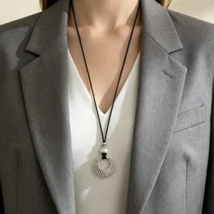 Silver hollow circular pendant long necklace with black cord, elegant sweater chain accessory.