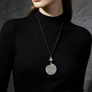 Close-up detail of the elegant silver hollow pendant necklace, showing intricate design.