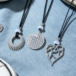 Detailed shot of three stylish silver pendant necklaces with unique geometric designs.