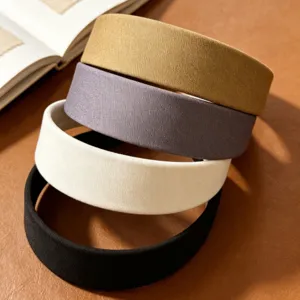 Close-up detail of wide fabric headbands in various colors neatly stacked for daily wear.
