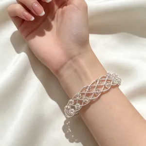 Primo piano dettagliato del braccialetto di perle di cristallo intrecciato in argento.