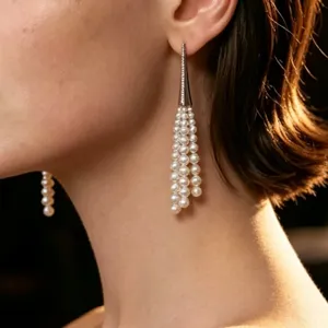 Close-up detail of elegant long pearl tassel earrings featuring sparkling cone setting.